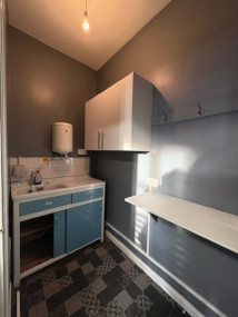 A photo of the kitchen, with sink, taps, cupboard space and some worktop space and hanging hooks