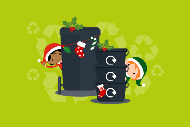 a comic drawing of 3 black recycling boxes, each with a recycle logo, stood atop each other, with two elves, one in red and one in green waving from behind the boxes.