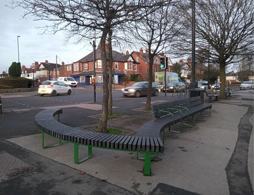 a view of the new bench seating, under a set of trees on Acomb Front Street