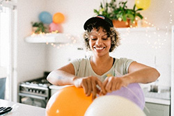 Person preparing for party, tying ballons.